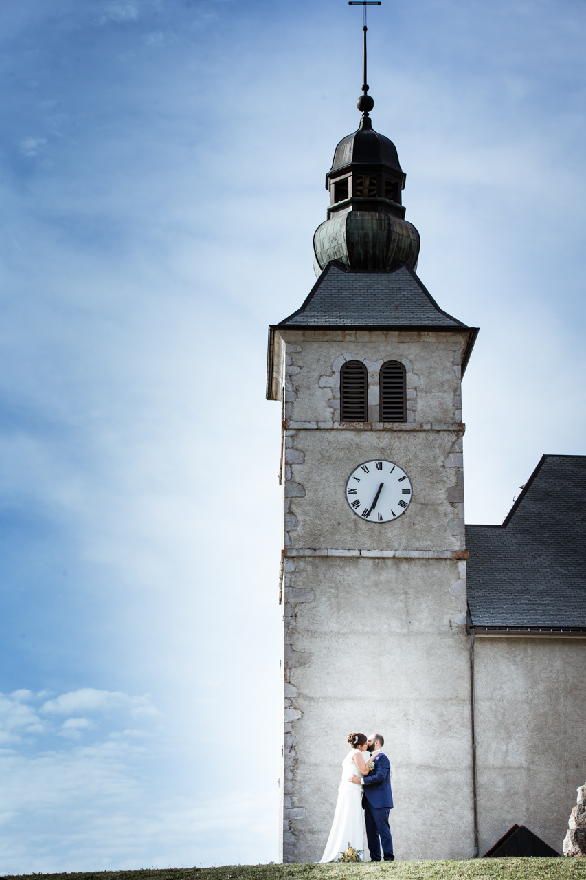 Mariage Mont Saxonnex photo de couple devant l'eglise avec ciel bleu